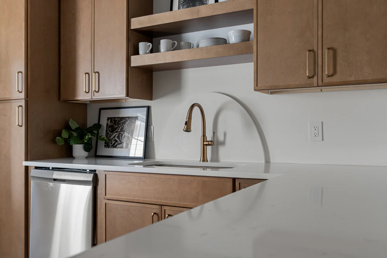 Brass faucet against an arched stone backsplash