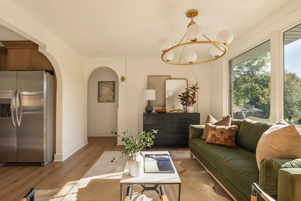 Living area with green sofa, brass chandelier and arched niche