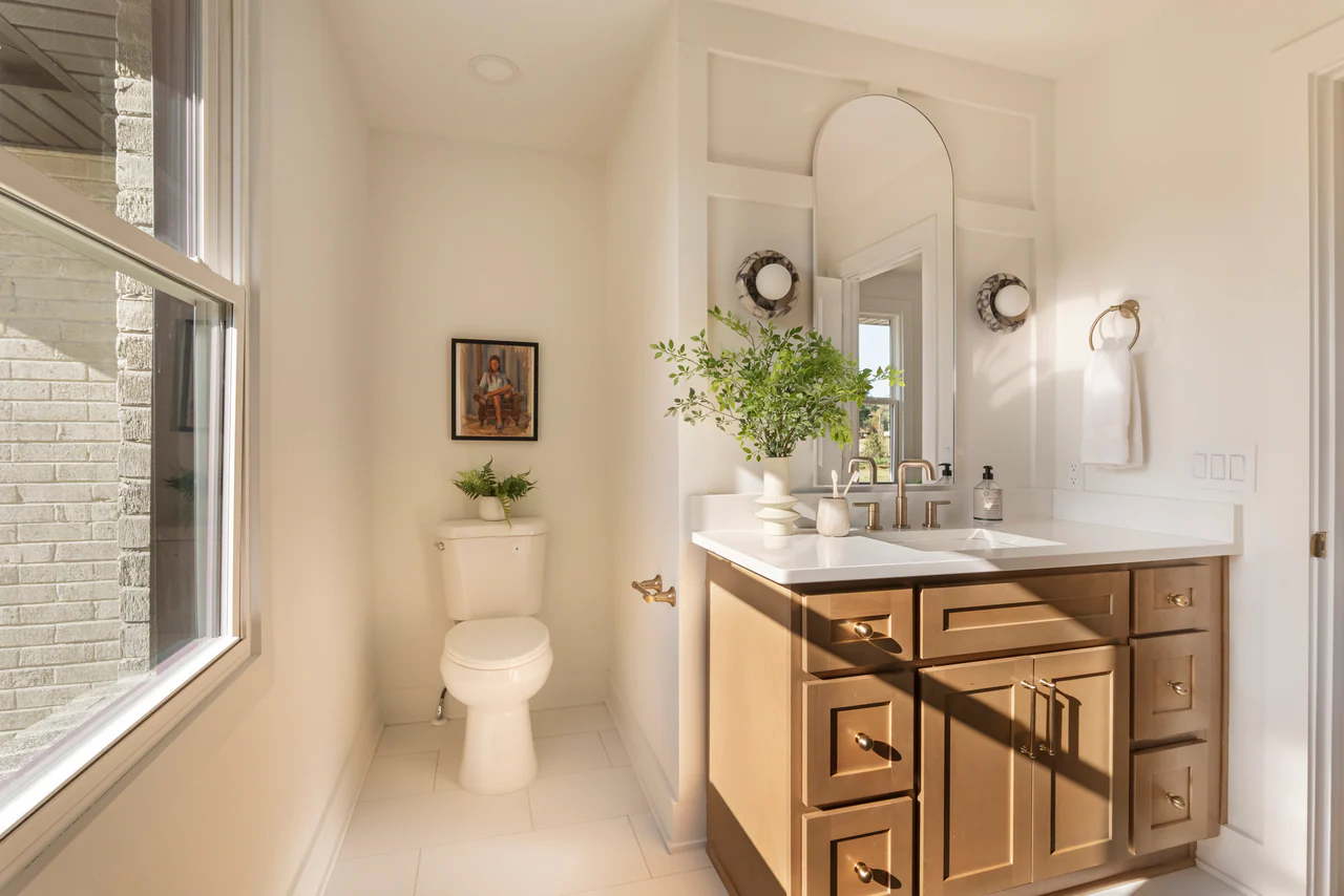 Bathroom with arched mirror and wood vanity
