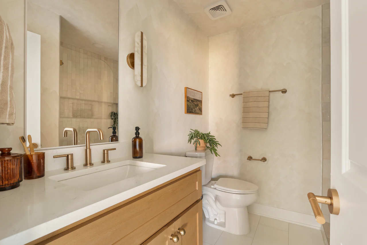 Bathroom with plaster walls and wood vanity