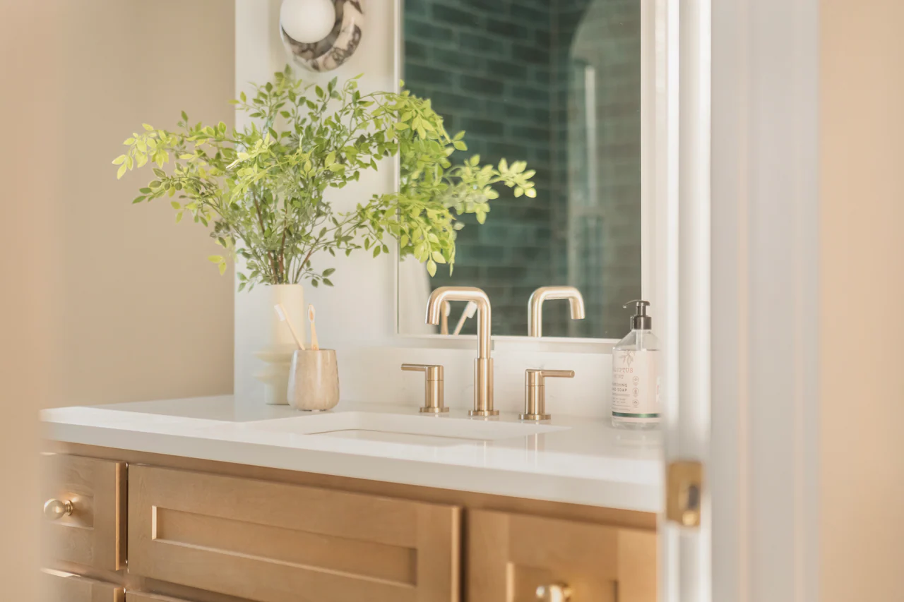 Vanity with brass faucet and mirror reflection
